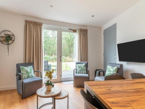 a living room with chairs and a flat screen tv at holiday home in Goirle with sauna in Goirle