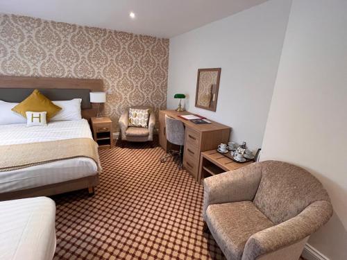 a hotel room with a bed and a chair and a desk at Haley's Hotel in Leeds