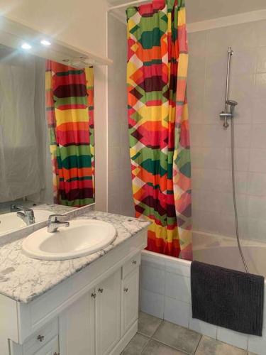 une salle de bain avec un lavabo et un rideau de douche dans l'établissement Les Appartements de La Marina, à Sanary-sur-Mer