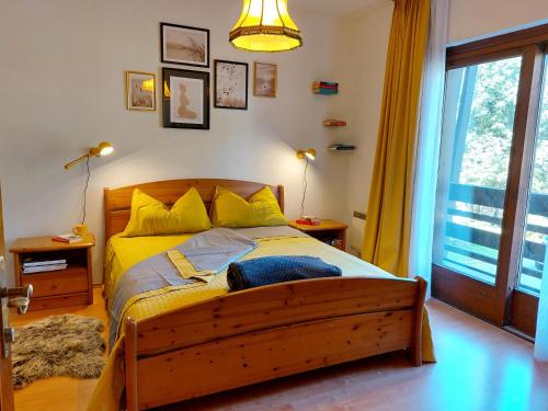 a bedroom with a large wooden bed with yellow sheets at Ski-to-door apartment Waldrand in Bad Kleinkirchheim