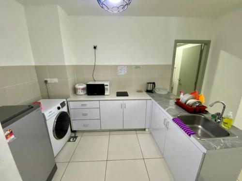a small kitchen with a sink and a washing machine at SA Sutera Avenue Homestay Opposite Imago KK in Kota Kinabalu