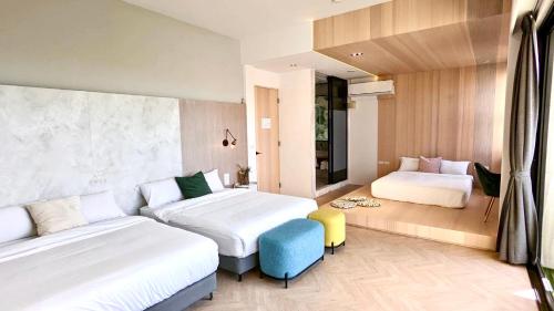 una habitación de hotel con 2 camas y una silla azul en AiMen Homestay, en Huxi