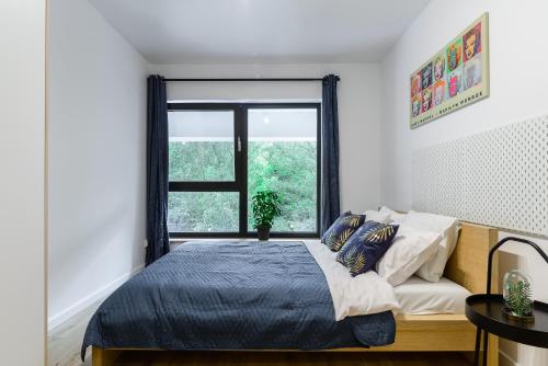 a bedroom with a bed and a window at Lumina I 2BR Apartment with Terrace I Parking I 100m2 I 2 Bathrooms in Łódź
