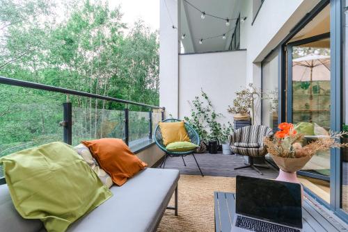 a living room with a couch and a laptop on a balcony at Lumina I 2BR Apartment with Terrace I Parking I 100m2 I 2 Bathrooms in Łódź