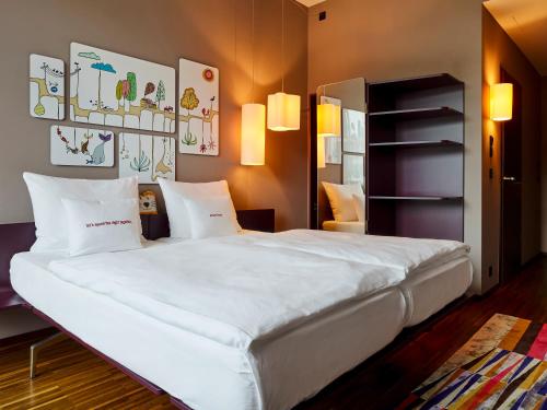 a bedroom with a large bed with white sheets at 25hours Hotel Zürich West in Zurich