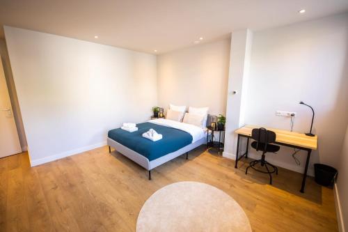 1 dormitorio con cama azul y escritorio en Distinct 2 bedroom Serviced Apartment 84m2 -VP2D- en Róterdam