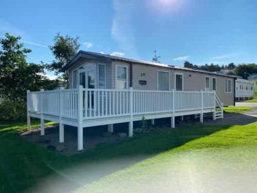 a mobile home with a porch and a deck at Craig Tara Glen Haven Caravan Dunure Village in Ayr