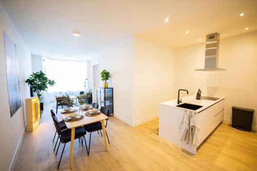 a kitchen and dining room with a table and a sink at Dearly 1 Bedroom Serviced Apartment 56m2 -NB306D- in Rotterdam