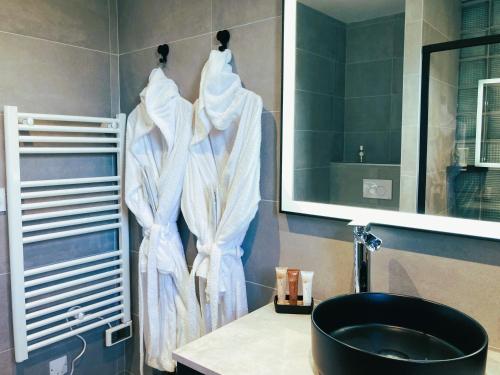 La salle de bains est pourvue d'un sèche-serviettes et d'un lavabo. dans l'établissement Studio & Spa La Discrète, à Saint-Évarzec