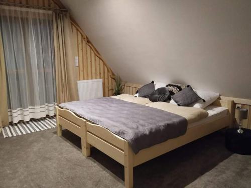 a bedroom with a large bed with pillows on it at Domek na Górce in Zakopane