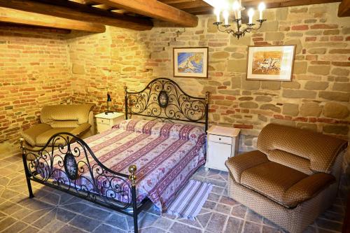 um quarto com uma cama grande e 2 cadeiras em Il Poggio em Mombaroccio