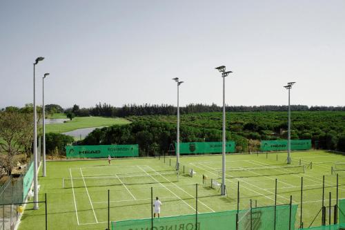 two people playing tennis on a tennis court at ROBINSON QUINTA DA RIA - All Inclusive in Vila Nova de Cacela