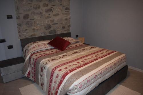 Un dormitorio con una cama con una almohada roja. en Prato del bue en San Cassiano