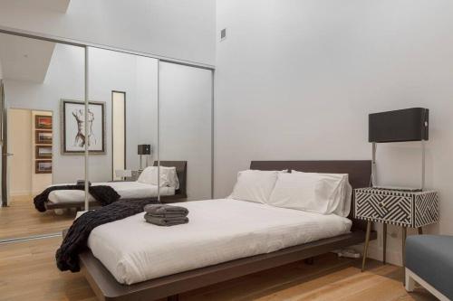 una camera da letto con un grande letto con lenzuola bianche di The Sophia a Melbourne