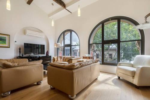 a large living room with two couches and a tv at The Sophia in Melbourne