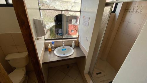 a small bathroom with a sink and a window at Hostal La Guayunga RoofTop in Quito