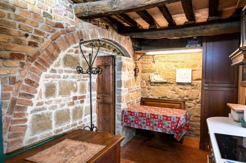 um quarto com uma mesa e uma parede de tijolos em Il Poggio em Mombaroccio