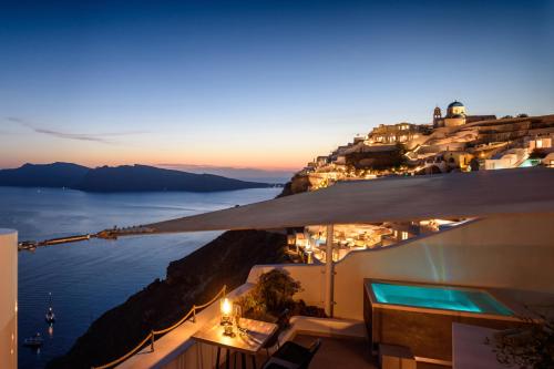 uma vista para o oceano a partir de uma varanda do hotel à noite em Strogili em Oia