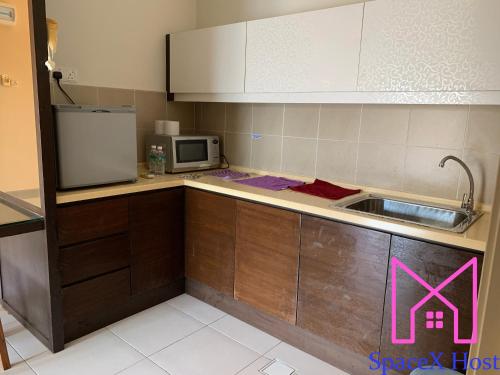 a kitchen with a sink and a microwave at Gold Coast Morib Resort in Banting