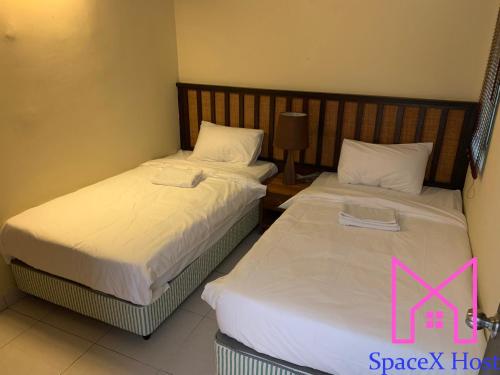 two beds sitting next to each other in a room at Gold Coast Morib Resort in Banting