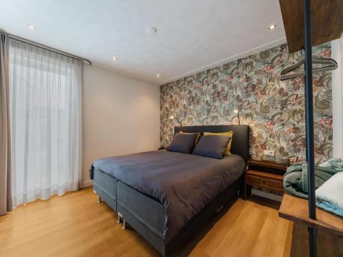 um quarto com uma cama e uma parede com um mural em Charming holiday home in Kaatsheuvel with hot tub em Kaatsheuvel