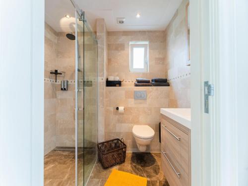 bagno con doccia in vetro e servizi igienici di Charming holiday home in Kaatsheuvel with hot tub a Kaatsheuvel