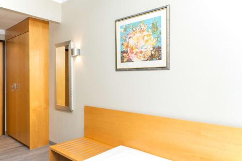 a room with a bed and a painting on the wall at elaya hotel hannover city in Hannover