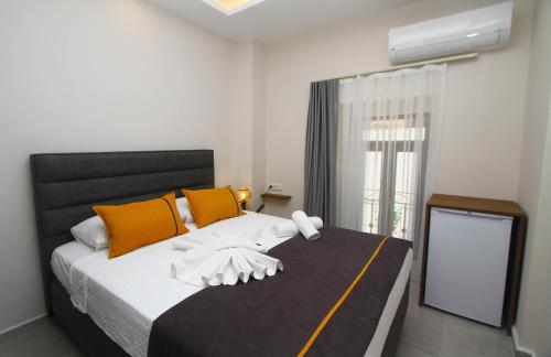a bedroom with a bed with orange and white pillows at Marinda Otel in Cesme