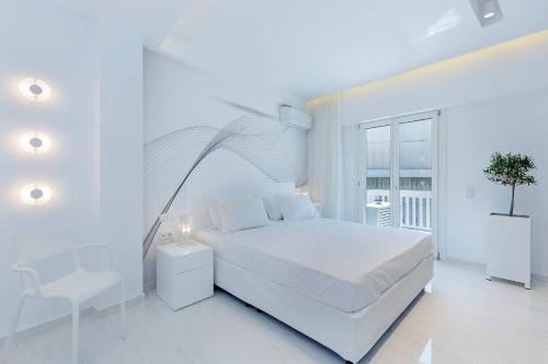 a white bedroom with a white bed and a balcony at Acropolis Amazing Apartment with Parthenon view in Athens