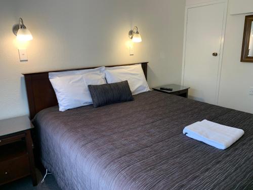 a bedroom with a large bed with two pillows at 755 Regal Court Motel in Dunedin