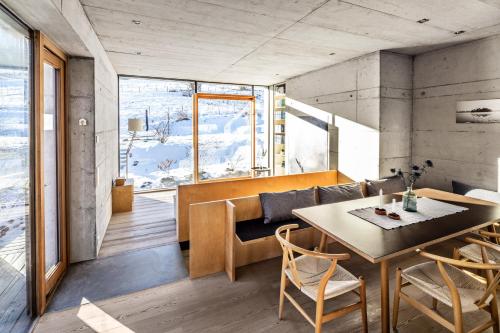 Zimmer mit einem Tisch und Stühlen sowie einem großen Fenster in der Unterkunft Bleibe in Bad Kohlgrub