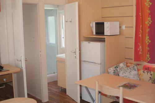 a small kitchen with a white refrigerator and a table at Altogold Swiss Holidays At Manor Farm 5* in Interlaken
