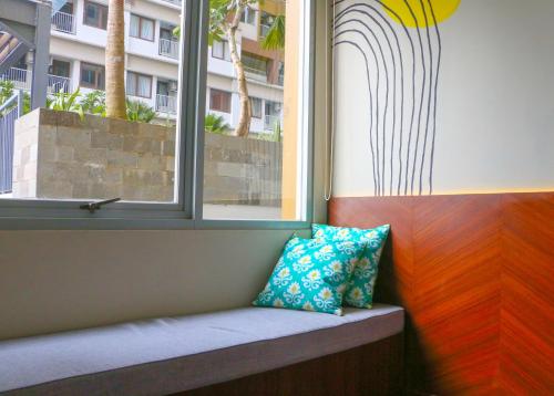 um assento na janela com duas almofadas ao lado de uma janela em Stay G Service Residence Jatibening em Kaliastana