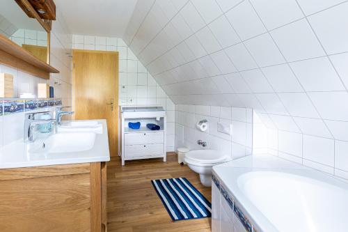 a white bathroom with a sink and a toilet at Ferienhaus Ankerherz in Wustrow