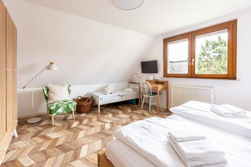 Un dormitorio con dos camas y un escritorio y una ventana. en Ferienhaus Ankerherz, en Wustrow
