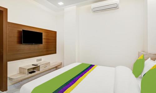 a bedroom with a bed with a tv on the wall at Treebo Paras Raj Near City Palace in Udaipur