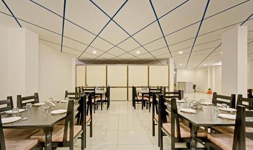 a dining room with tables and chairs and a ceiling at Treebo Paras Raj Near City Palace in Udaipur