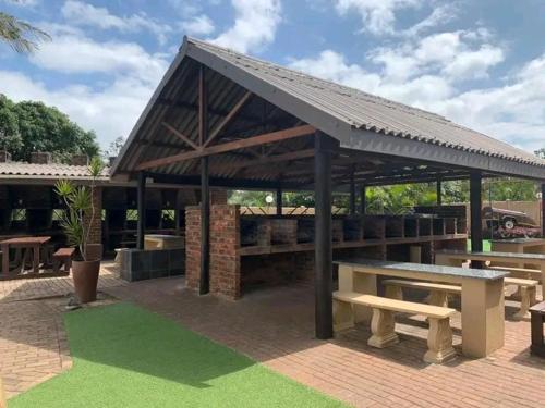 a pavilion with a picnic table and benches at 102 Santana Holiday Resort in Margate