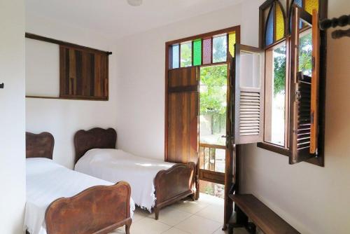 a bedroom with two beds and stained glass windows at Pousart - Floripa in Florianópolis