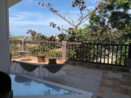 um pátio com uma mesa, uma cerca e uma piscina em Pousart - Floripa em Florianópolis