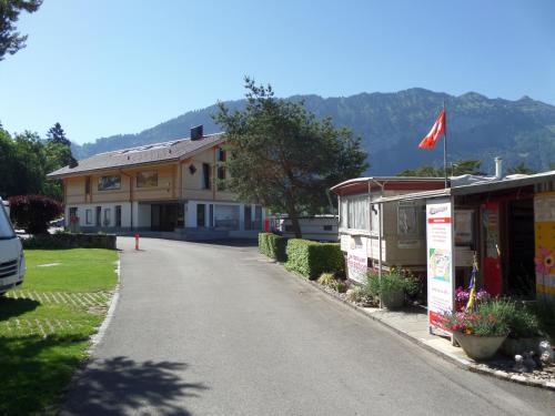 a house with a flag on the side of a road at Altogold Swiss Holidays At Manor Farm 5* in Interlaken