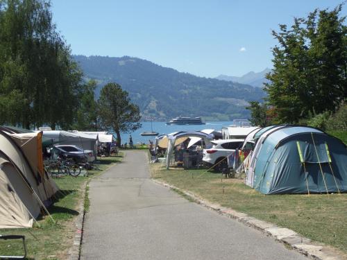 a group of tents parked next to a lake at Altogold Swiss Holidays At Manor Farm 5* in Interlaken