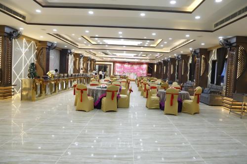 a banquet hall with tables and chairs in a room at THE BODHI PALACE RESORT in Bodh Gaya