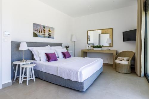 - une chambre avec un grand lit et des oreillers violets dans l'établissement Villa Antigone Luxury Retreat, à Skopelos