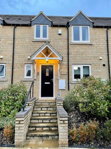 a brick house with a staircase leading to a door at Lion Cottage, Broadway in Broadway