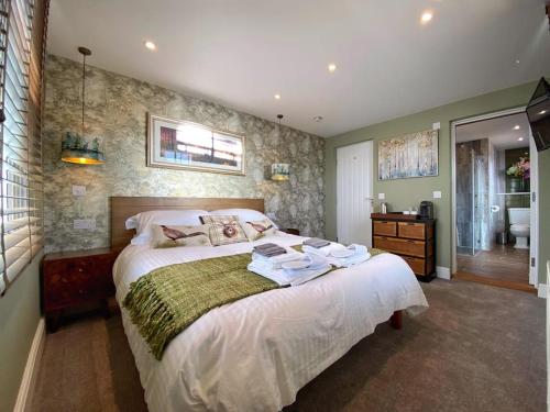 a bedroom with a large bed and a bathroom at Hambrook Guest Suites and Private ESPA Spa in Canterbury