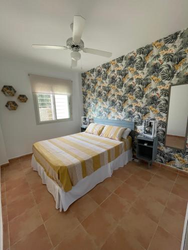 1 dormitorio con 1 cama y pared cubierta de papel pintado en Luminoso y tranquilo bajo con Jardin en campo de Golf Valle del Este, en Vera