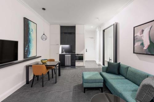 a living room with a green couch and a table at Adina Apartment Hotel Brisbane in Brisbane