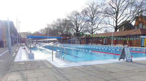 an empty swimming pool with a ramp and a sign at Beautiful apartment right off of Broadway Market in London