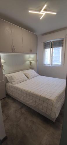 - une chambre avec un grand lit blanc dans l'établissement sommacon house, à Sanremo